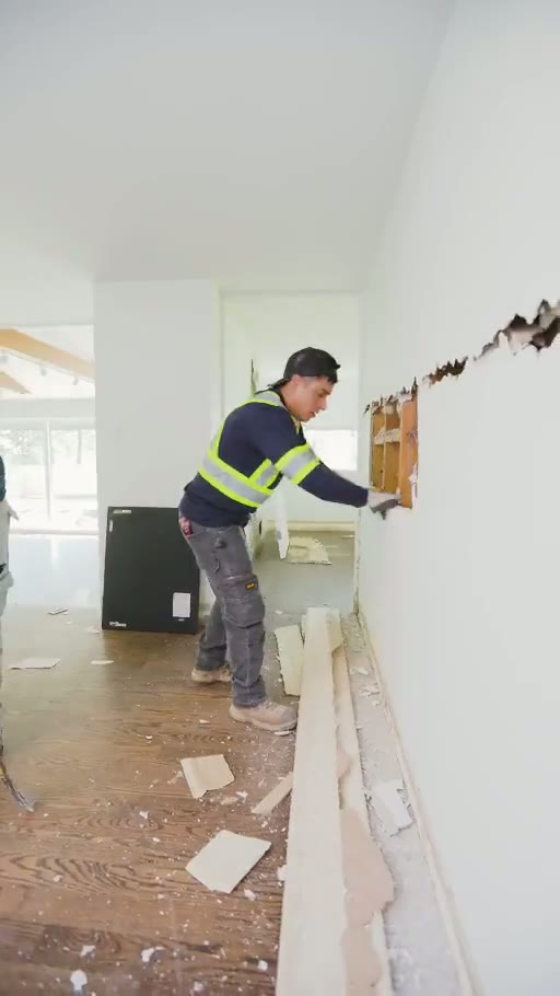 Pinemar worker carefully removing a section of drywall in a renovation