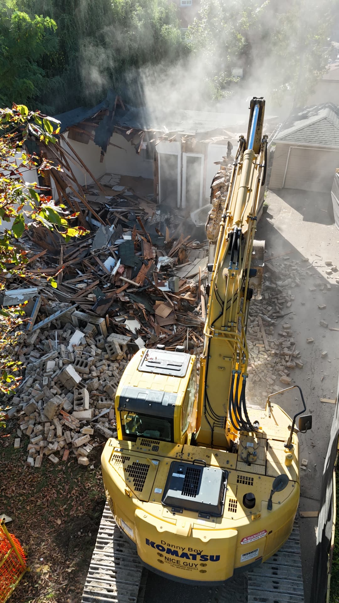 Pinemar excavator demolishing part of a brick house