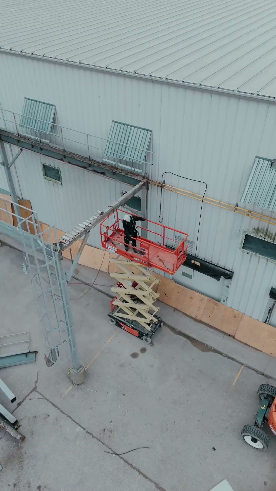 Worker on a scissor lift removing steel at a commercial building demolition